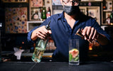A bartender behind bar making cocktail