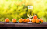 Apricot brandy and ripe apricots on wooden table