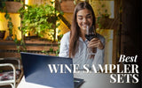 Woman holding wine glass looking at laptop