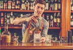 Expert barman is making cocktail night club bar